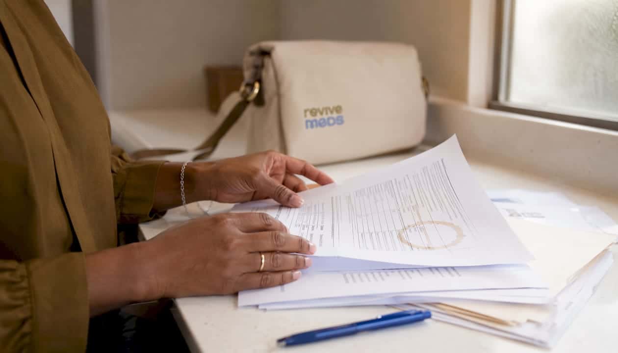 Hands checking pharmacy registration documents