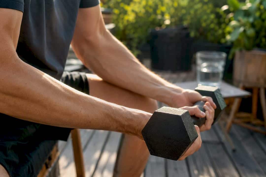 Hands gripping dumbbell during strength training